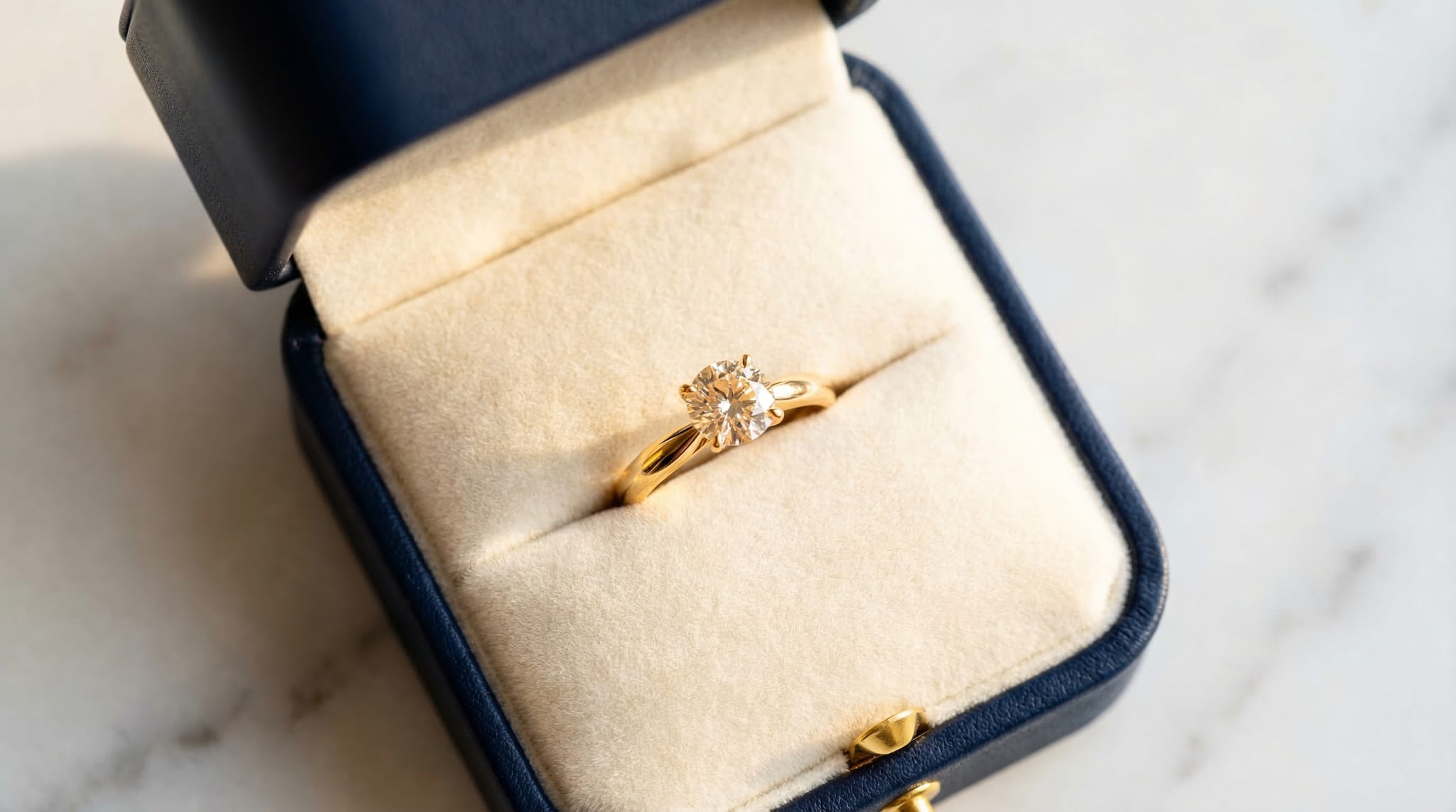 Close-up of engagement ring box interiors showing velvet cushion insert, die-cut foam slot, and ribbon pull detail